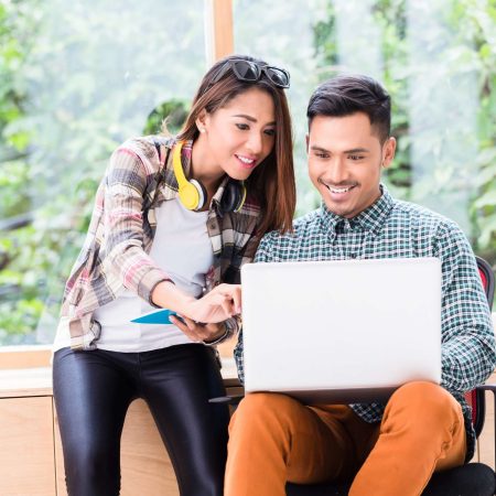 Two employees talking about something on a laptop